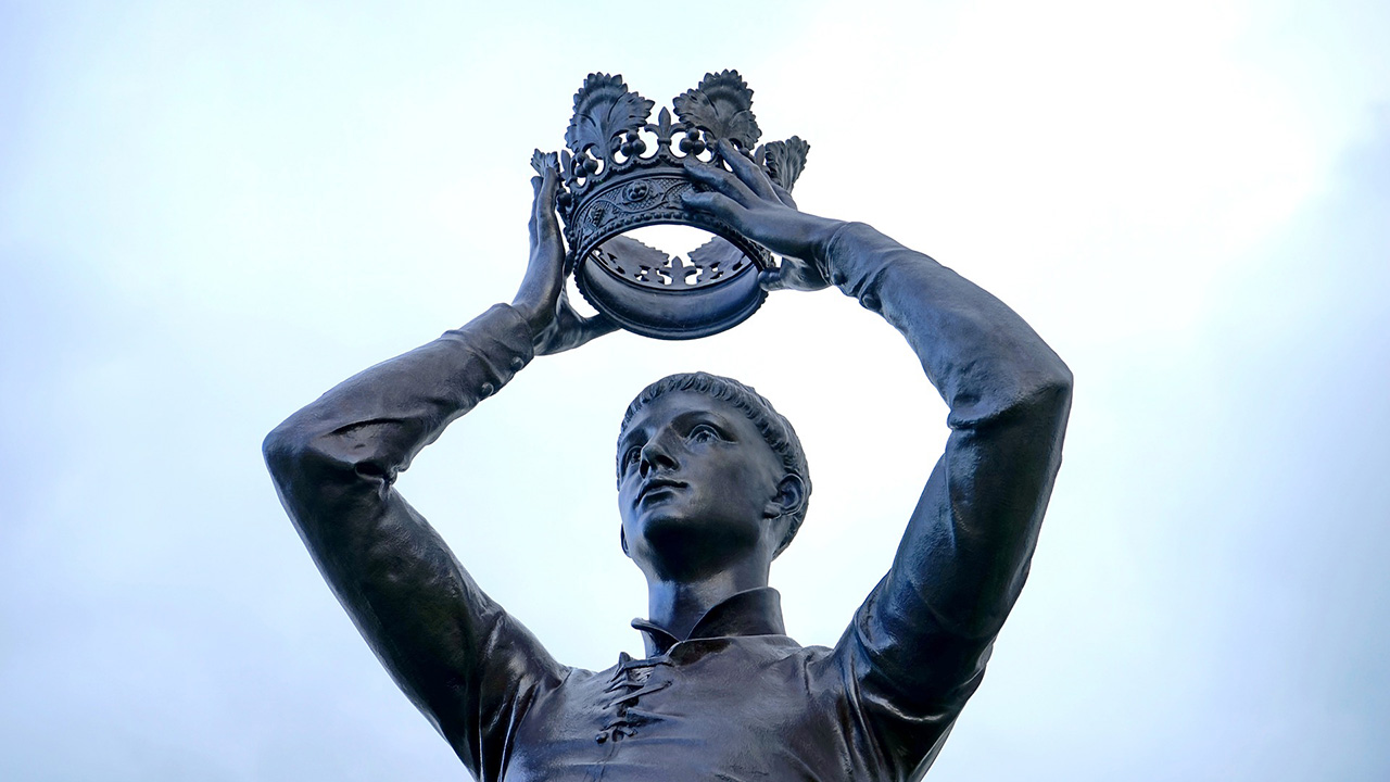 Bronze statue of a man holding a crown