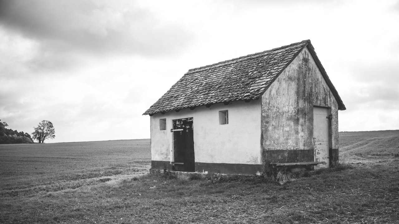 An old house on a grassy plain.