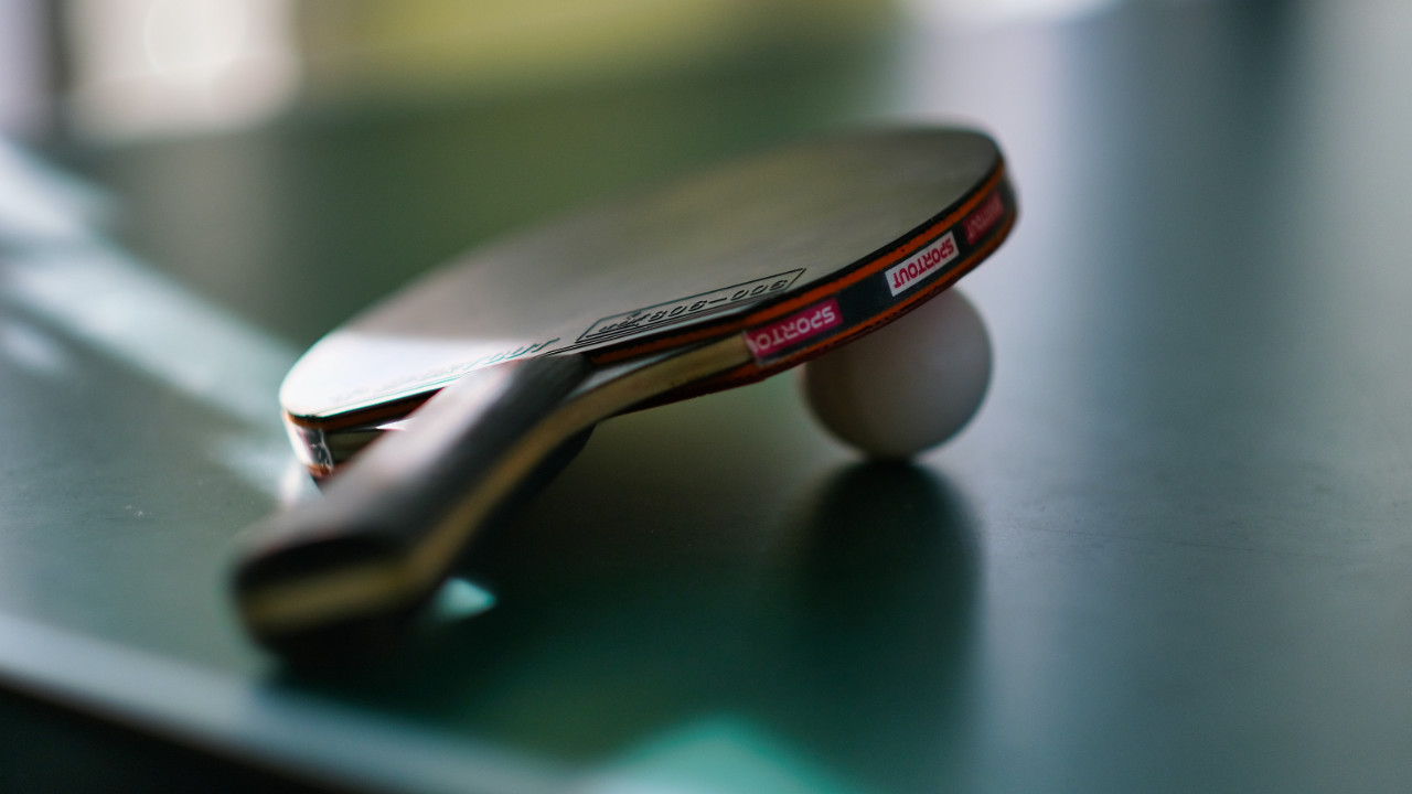 A ping pong paddle and ball.
