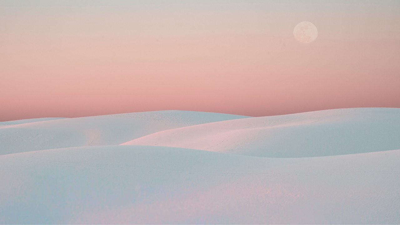 An orange sunset over white sands