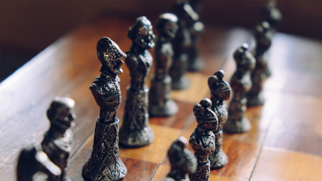 Antique chess pieces on a wooden board