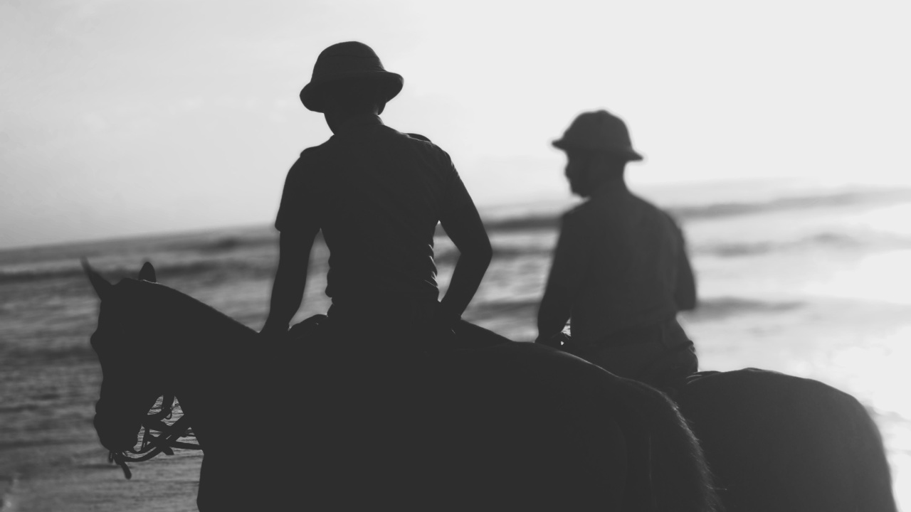 Two horseback riders on the beach