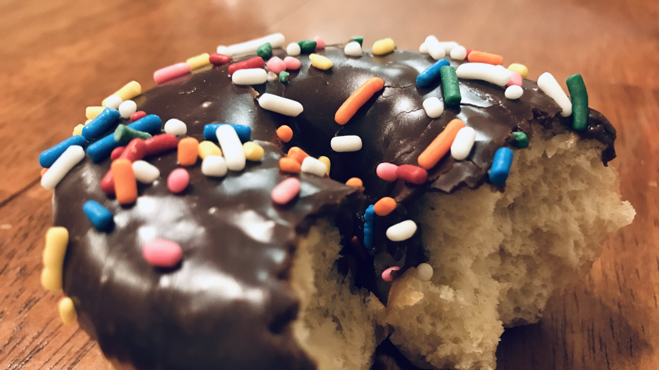 Closeup of sprinkles on a chocolate ring donut