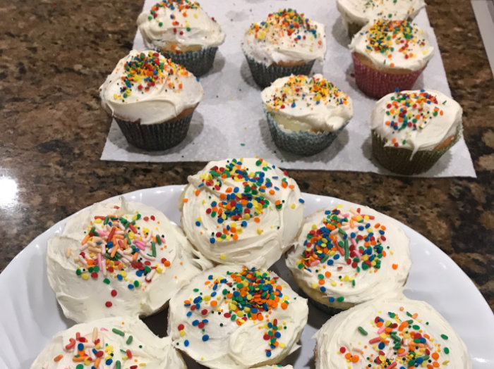 Vanilla cupcakes with white buttercream icing and rainbow-color sprinkles