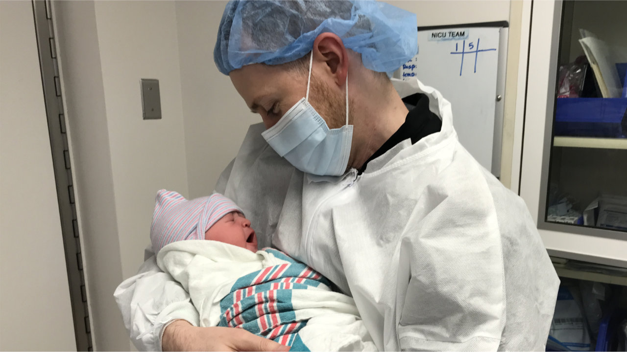 Jonathan holding a newborn baby Olivia